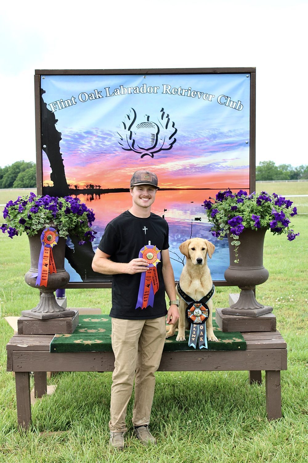 Devin with a titled yellow Labrador and competition ribbons