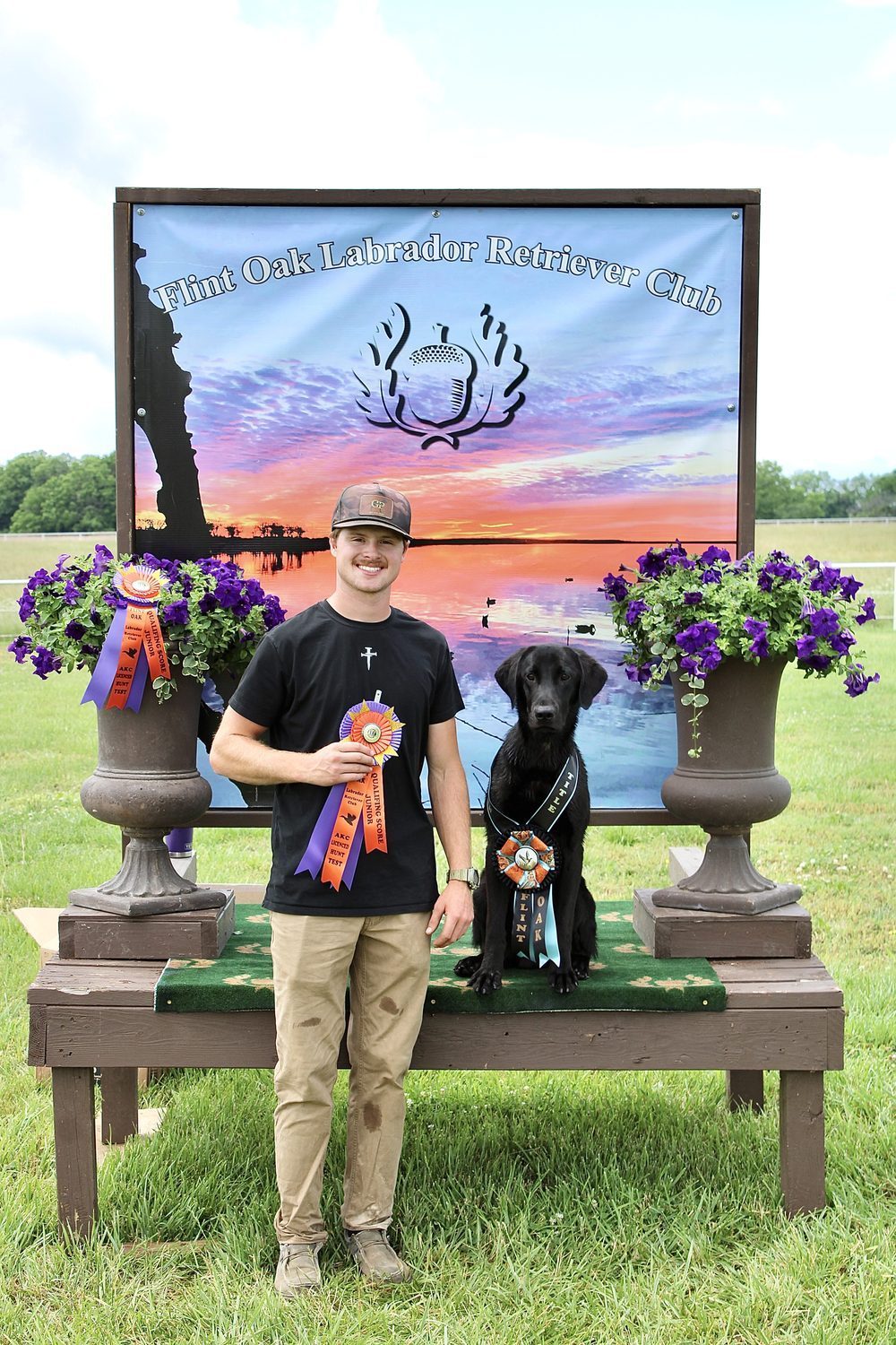 Devin with a black Labrador and ribbons