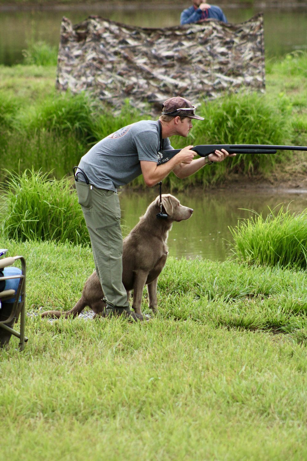 Devin running a dog on a hunt test with a shotgun